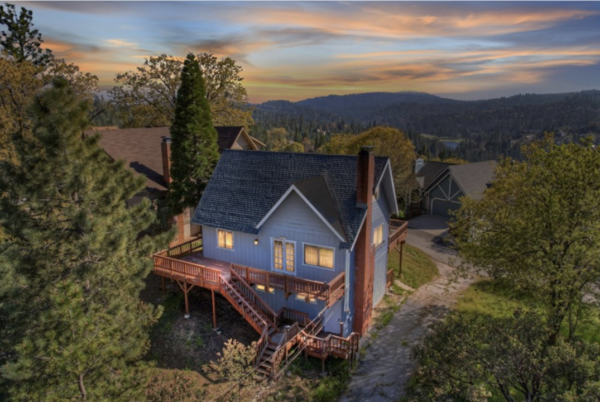 Cozy house at sunset in forested area.